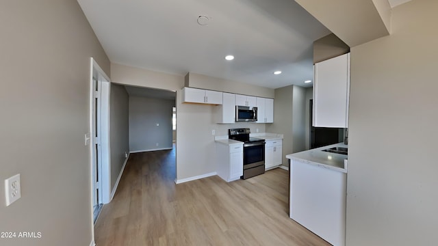 kitchen featuring white cabinetry, light hardwood / wood-style flooring, and appliances with stainless steel finishes