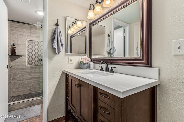 7777 E Main St Unit 143, Scottsdale, AZ 85251 - bathroom featuring a textured wall, vanity, and a tile shower