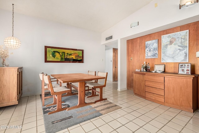 tiled dining space featuring lofted ceiling