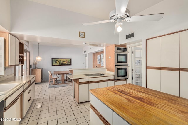 kitchen with white cabinets, light tile patterned floors, ceiling fan, stainless steel double oven, and black electric cooktop