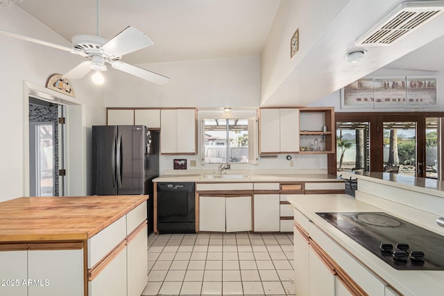 kitchen with sink, black appliances, light tile patterned floors, ceiling fan, and white cabinets