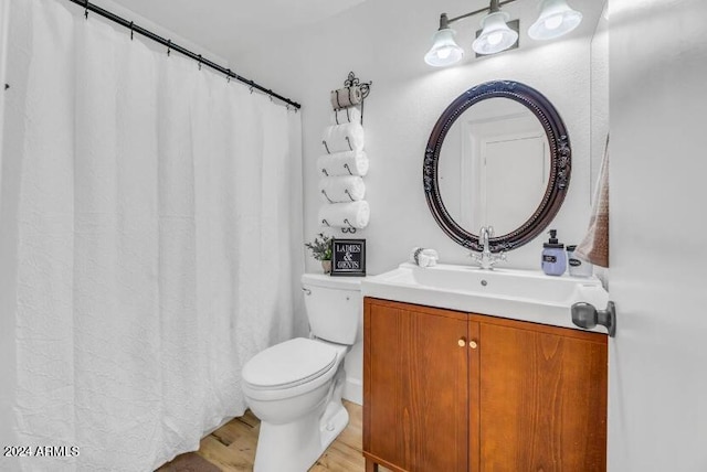 bathroom with wood-type flooring, toilet, and vanity