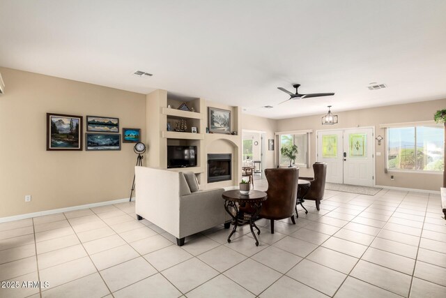 2075 W Silverlode Dr, Wickenburg, AZ 85390 - living area with baseboards, ceiling fan, a glass covered fireplace, and light tile patterned floors