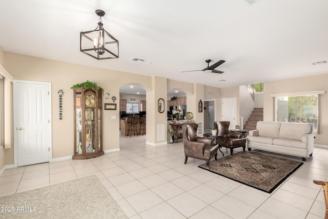 2075 W Silverlode Dr, Wickenburg, AZ 85390 - living area featuring stairway, arched walkways, ceiling fan, light tile patterned flooring, and baseboards