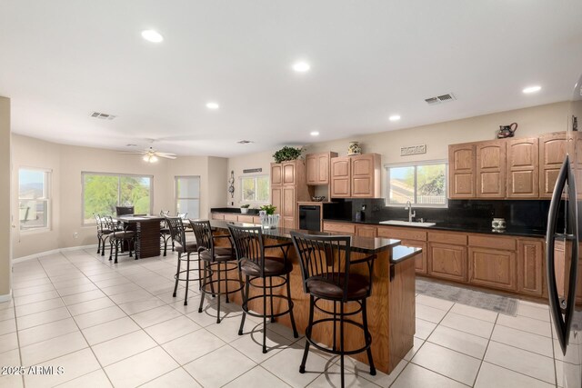 2075 W Silverlode Dr, Wickenburg, AZ 85390 - kitchen with a sink, a kitchen breakfast bar, a kitchen island, recessed lighting, and light tile patterned flooring