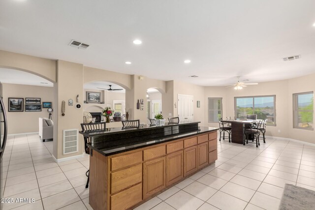 2075 W Silverlode Dr, Wickenburg, AZ 85390 - kitchen featuring a ceiling fan, light tile patterned floors, arched walkways, recessed lighting, and a kitchen island