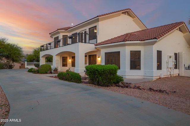 2075 W Silverlode Dr, Wickenburg, AZ 85390 - view of front of home featuring a balcony, a tiled roof, a porch, and stucco siding