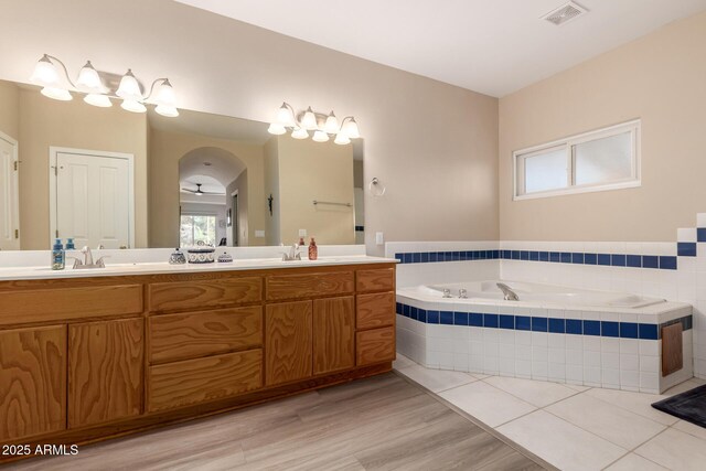 2075 W Silverlode Dr, Wickenburg, AZ 85390 - full bathroom with a garden tub, double vanity, healthy amount of natural light, and wood finished floors