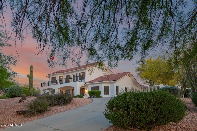 2075 W Silverlode Dr, Wickenburg, AZ 85390 - mediterranean / spanish-style home featuring a balcony, stucco siding, curved driveway, and a tile roof