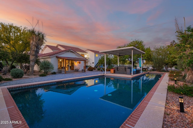 2075 W Silverlode Dr, Wickenburg, AZ 85390 - pool at dusk featuring a patio, an outdoor pool, and an outdoor kitchen