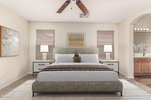 bedroom featuring ensuite bath, light colored carpet, and ceiling fan