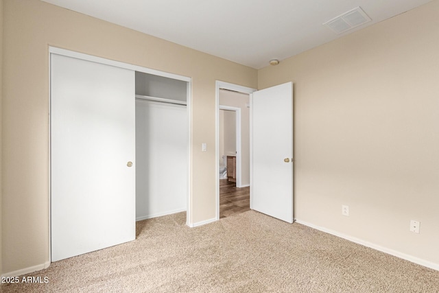 unfurnished bedroom with light colored carpet and a closet