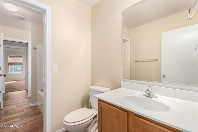 full bathroom featuring hardwood / wood-style flooring, vanity, shower / bathtub combination, and toilet