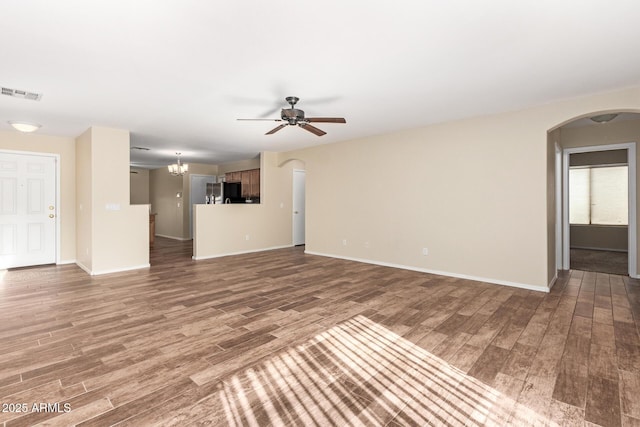 unfurnished living room featuring hardwood / wood-style flooring and ceiling fan with notable chandelier