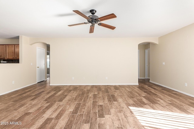 unfurnished living room featuring ceiling fan and light wood-type flooring