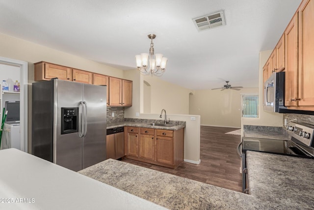 kitchen with pendant lighting, sink, appliances with stainless steel finishes, backsplash, and kitchen peninsula