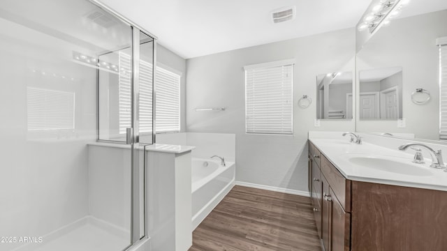 2668 N 73rd Gln, Phoenix, AZ 85035 - bathroom featuring baseboards, a shower stall, double vanity, and wood finished floors