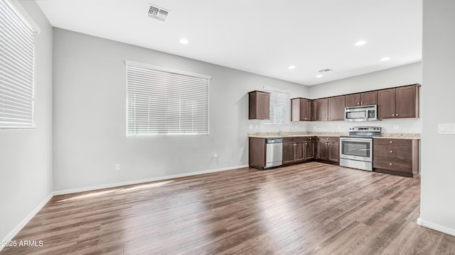 2668 N 73rd Gln, Phoenix, AZ 85035 - kitchen with appliances with stainless steel finishes, dark brown cabinetry, light wood-style floors, baseboards, and recessed lighting
