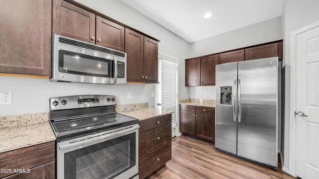 2668 N 73rd Gln, Phoenix, AZ 85035 - kitchen featuring appliances with stainless steel finishes, dark brown cabinets, wood finished floors, light stone counters, and recessed lighting
