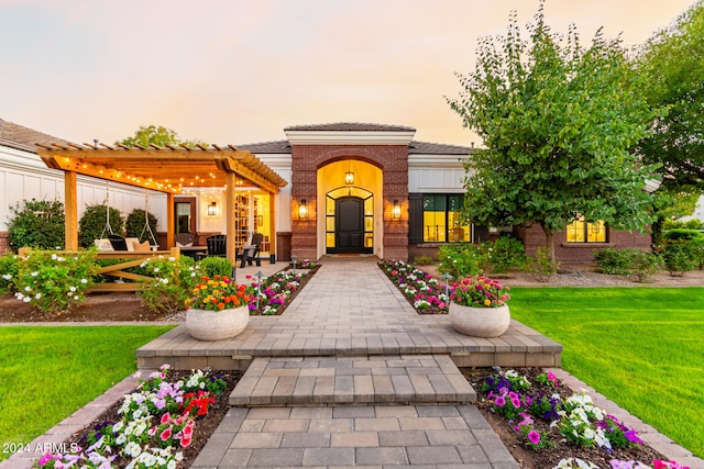 mediterranean / spanish-style house featuring a pergola and a yard