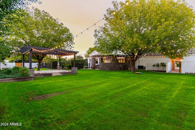 yard at dusk featuring a pergola