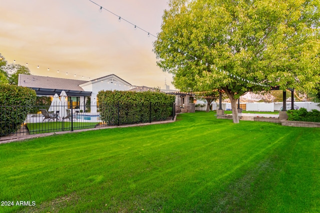 yard at dusk with a fenced in pool