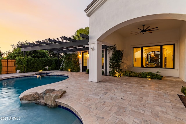 pool at dusk featuring ceiling fan, a patio, a pergola, and an in ground hot tub