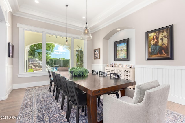 dining area featuring wood-type flooring, crown molding, and a tray ceiling