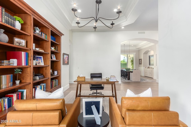 office area with a notable chandelier, ornamental molding, and light hardwood / wood-style flooring