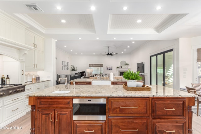 kitchen with ceiling fan, white cabinets, light hardwood / wood-style floors, and stainless steel appliances