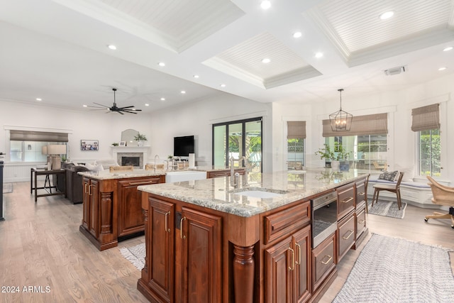 kitchen featuring hanging light fixtures, light hardwood / wood-style floors, a large island, and coffered ceiling