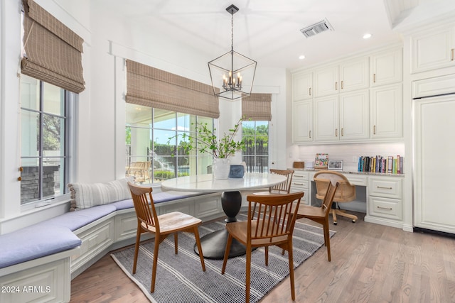 dining room with plenty of natural light, light hardwood / wood-style floors, and built in desk