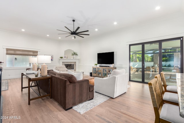 living room with light hardwood / wood-style floors, ceiling fan, and crown molding