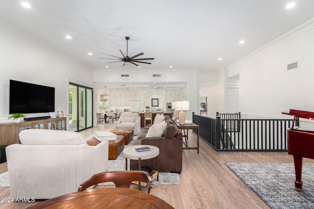 living room with ornamental molding, ceiling fan, and light hardwood / wood-style floors