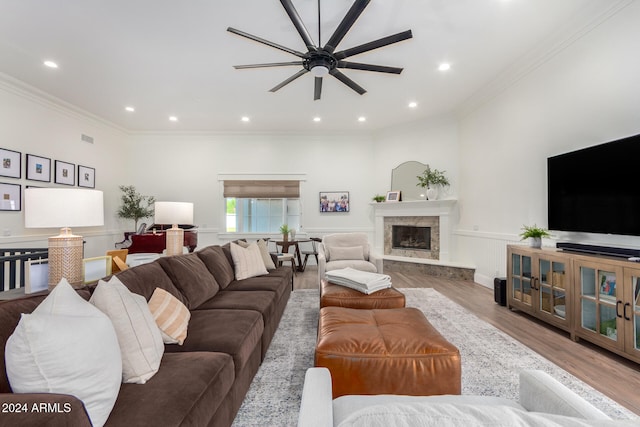 living room featuring ornamental molding, a fireplace, hardwood / wood-style flooring, and ceiling fan