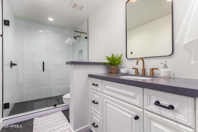 bathroom featuring an enclosed shower, vanity, and toilet