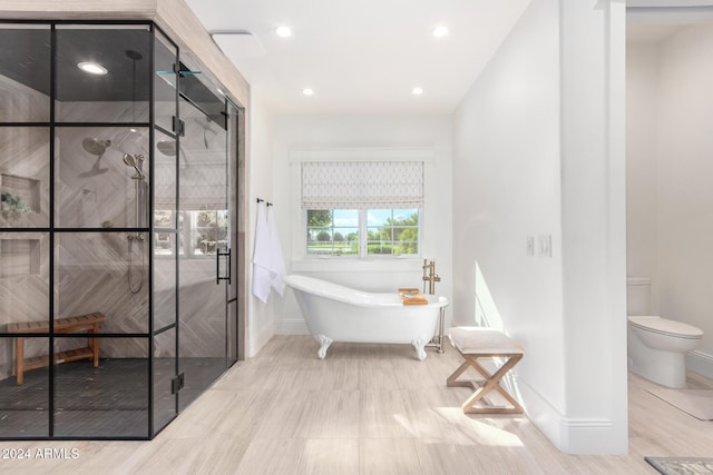 bathroom featuring toilet, wood-type flooring, and separate shower and tub