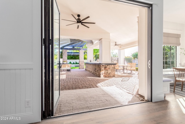 doorway to outside with wood-type flooring and ceiling fan