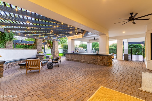 view of patio / terrace featuring a bar, outdoor lounge area, a pergola, and ceiling fan