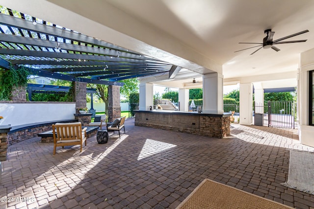 view of patio / terrace featuring ceiling fan, exterior bar, a pergola, and an outdoor hangout area