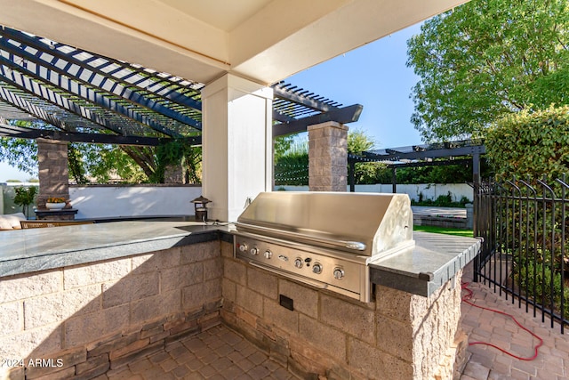 view of patio with exterior kitchen, grilling area, and a pergola