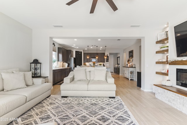 living room featuring ceiling fan and light hardwood / wood-style flooring