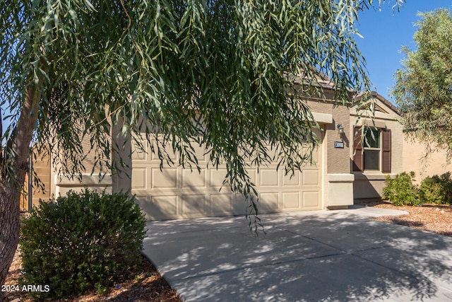 view of property hidden behind natural elements featuring a garage