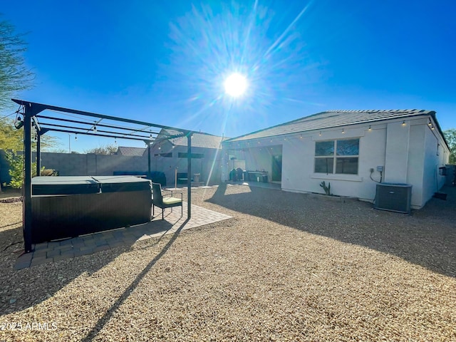 view of side of home featuring a pergola, a hot tub, central air condition unit, and a patio area