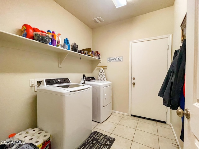 washroom with washer and clothes dryer and light tile patterned floors