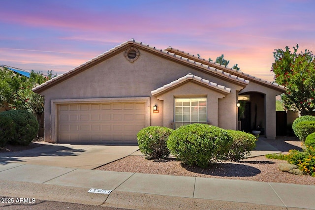 11861 E Becker Ln, Scottsdale, AZ 85259 - mediterranean / spanish house with an attached garage, driveway, stucco siding, and a tiled roof