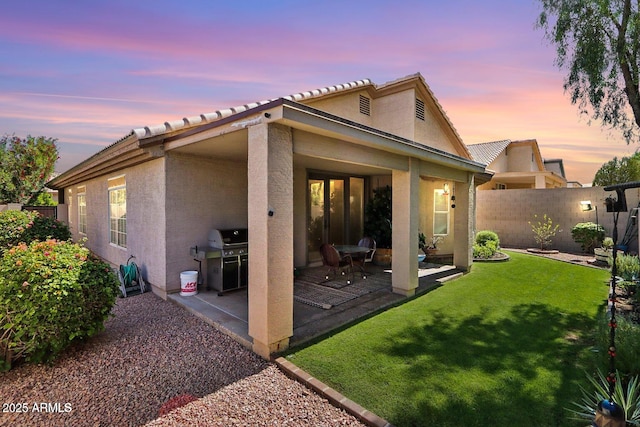 11861 E Becker Ln, Scottsdale, AZ 85259 - back of property at dusk with stucco siding, a patio area, and a tile roof