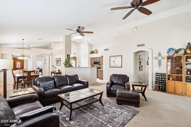 11861 E Becker Ln, Scottsdale, AZ 85259 - living area featuring arched walkways, a ceiling fan, light colored carpet, and high vaulted ceiling