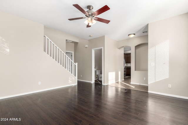 unfurnished living room with ceiling fan and dark wood-type flooring