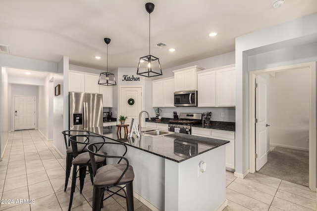 kitchen featuring white cabinets, sink, an island with sink, and appliances with stainless steel finishes